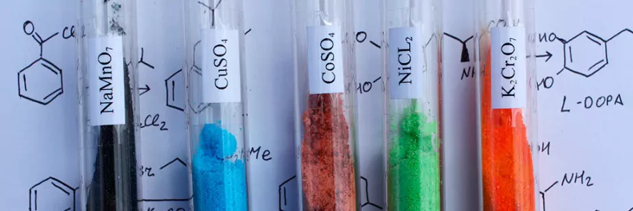 tubos com substâncias químicas em cima de folha com desenhos de elementos