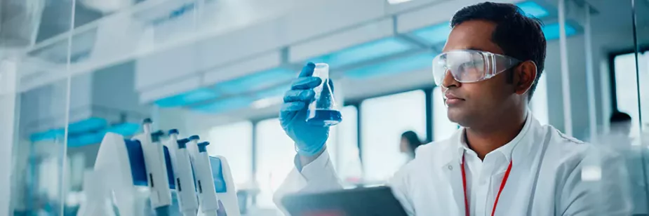 homem em laboratório observando componente azul em recipiente