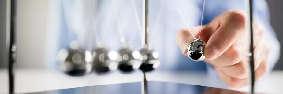 Homem segurando pêndulo de metal