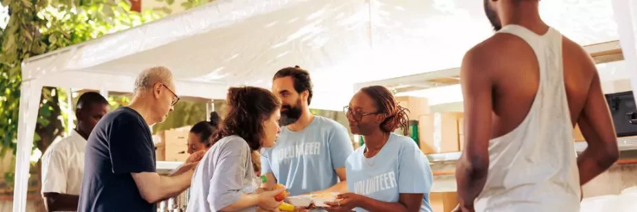 grupo de voluntarios distribuindo alimentos para pessoas