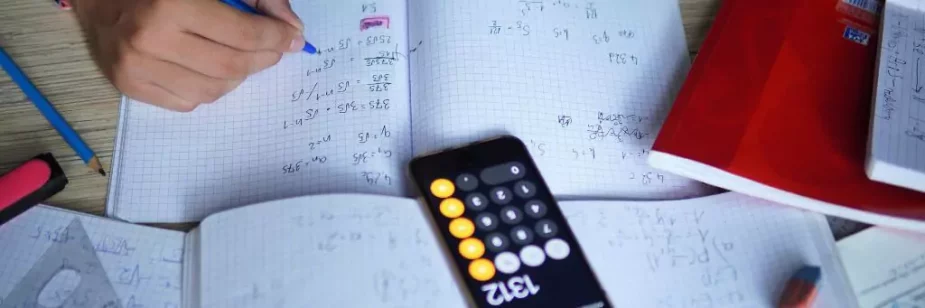 rapaz estudando matematica com caderno e calculadora