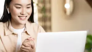 moça sorridente em frente a computador