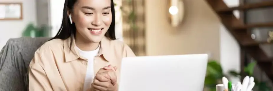 moça sorridente em frente a computador